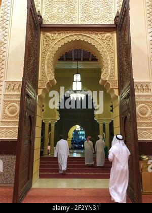 Vue sur les hommes émirat entrer dans la mosquée Bin Hamoodah Banque D'Images