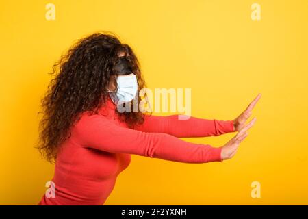 Femme avec masque et bandeau. Concept d'incertitude. Fond jaune Banque D'Images