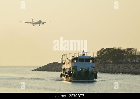 Ferry pour passagers exploité par Fortune Ferry à l'approche de Sha Lo WAN Pier, avec un atterrissage d'avion au-dessus de l'aéroport international de Hong Kong Banque D'Images