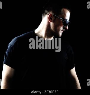 Mode élégant jeune homme portrait sur fond noir Banque D'Images