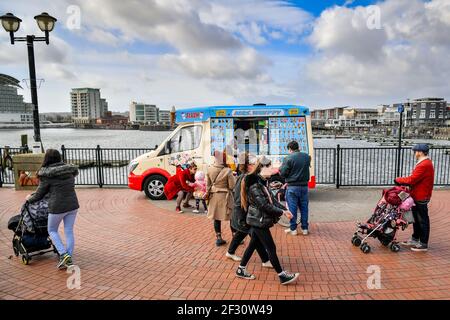 Les gens font la queue pour une fourgonnette glacée dans la baie de Cardiff, au pays de Galles, où les restrictions de séjour à la maison sont assouplies et où les gens sont autorisés à voyager dans leur région, y compris pour rencontrer de la famille et des amis qui vivent dans la région tant qu'il est à l'extérieur. Date de la photo: Dimanche 14 mars 2021. Banque D'Images