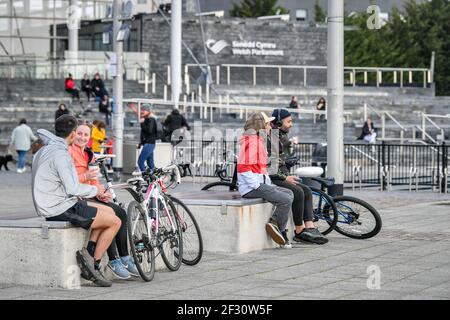 Les gens se détendent dans la baie de Cardiff, au pays de Galles, où les restrictions de séjour à la maison sont assouplies et où les gens sont autorisés à voyager dans leur région, y compris pour rencontrer de la famille et des amis qui vivent dans la région tant qu'il est à l'extérieur. Date de la photo: Dimanche 14 mars 2021. Banque D'Images