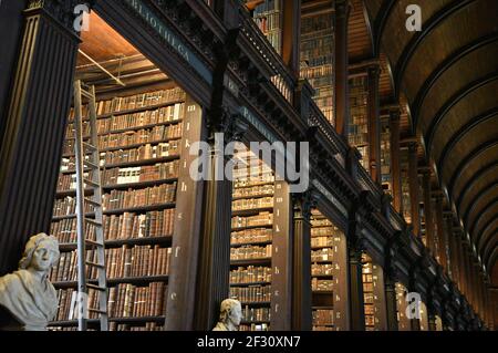 Librairies avec des livres imprimés et manuscrits précieux dans la salle longue de l'ancienne bibliothèque du Trinity College à Dublin, Irlande. Banque D'Images