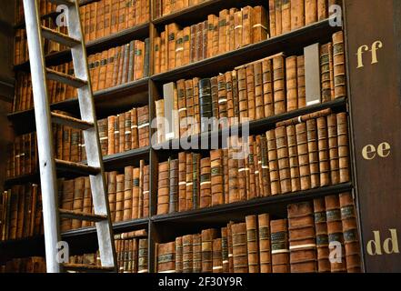 Librairies avec des livres imprimés et manuscrits précieux dans la salle longue de l'ancienne bibliothèque du Trinity College à Dublin, Irlande. Banque D'Images