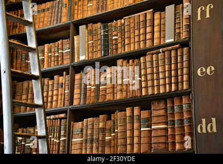 Librairies avec des livres imprimés et manuscrits précieux dans la salle longue de l'ancienne bibliothèque du Trinity College à Dublin, Irlande. Banque D'Images