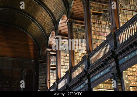 Librairies avec des livres imprimés et manuscrits précieux dans la salle longue de l'ancienne bibliothèque du Trinity College à Dublin, Irlande. Banque D'Images