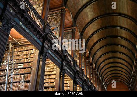 Librairies avec des livres imprimés et manuscrits précieux dans la salle longue de l'ancienne bibliothèque du Trinity College à Dublin, Irlande. Banque D'Images