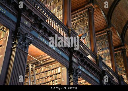 Librairies avec des livres imprimés et manuscrits précieux dans la salle longue de l'ancienne bibliothèque du Trinity College à Dublin, Irlande. Banque D'Images