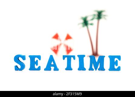 Texte TEMPS DE MER fait de lettres en bois avec des palmiers flous et un parasol sur l'arrière-plan. Banque D'Images