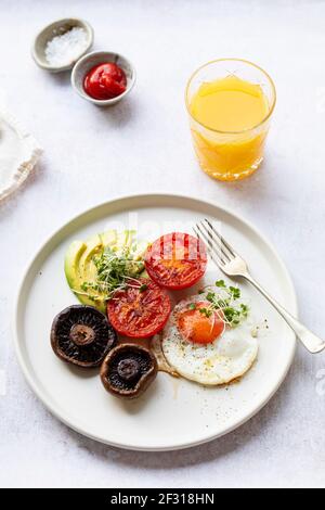 Petit-déjeuner végétarien avec œufs frits, tomates, champignons et avocat Banque D'Images