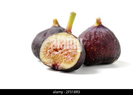 Fruits frais de figue pourpre et tranches isolées sur fond blanc, les figues sont riches en calcium et contient des antioxydants il aide à prévenir la constipation et Banque D'Images