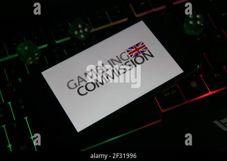 Viersen, Allemagne - 1er mars. 2021: Gros plan du smartphone avec le logo de l'agence de réglementation de la commission de jeu britannique sur le clavier d'ordinateur Banque D'Images