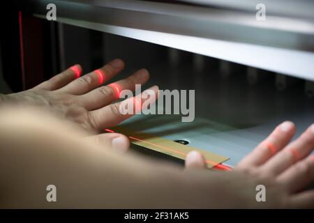 Femme sans visage qui a mis en place une machine à couper le papier Banque D'Images