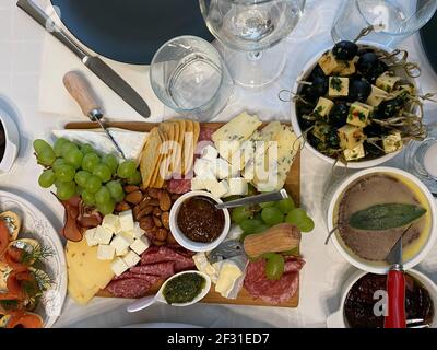 viande froide et plusieurs types de fromages, olives, raisins marinés sur une planche de bois. En-cas au vin, assiette de fromages Banque D'Images