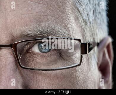 Homme demi-visage verres oeil mature homme 50-55 ans lunettes de vue de marque avec lunettes de vue bleu clair vue directe vers l'avant Banque D'Images