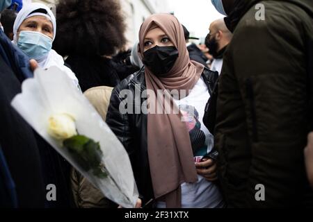 Les gens tiennent des fleurs lors d'une marche blanche à la mémoire d'une fille de 14 ans, dont le corps battu a été trouvé dans la Seine après avoir subi du harcèlement en ligne à l'école, à Argenteuil, le 14 mars 2021. Un juge français a inculpé deux enfants de 15 ans du meurtre d'une fille de leur école, identifiée seulement comme Alisha, qui avait été victime d'intimidation en ligne dans un conflit avec les suspects, un garçon et une fille. Photo de Raphael Lafargue/ABACAPRESS.COM Banque D'Images