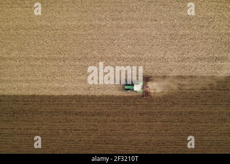 Vue aérienne des champs labourés et labourés des tracteurs agricoles, directement au-dessus de l'image de drone pov des machines travaillant sur les terres agricoles Banque D'Images