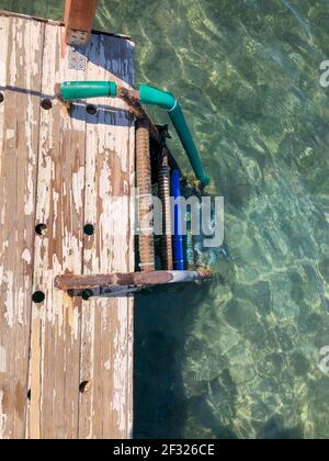 ancienne échelle rouillée descendant de la jetée en bois à la mer Banque D'Images