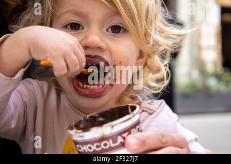 Bébé fille mangeant de glace au chocolat Banque D'Images