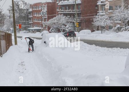 Pelleter la neige dehors en camionnette après tempête, mars 2017, Montréal, QC Banque D'Images