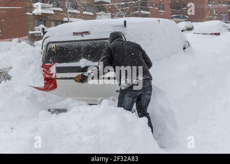 Pelleter la neige dehors en camionnette après tempête, mars 2017, Montréal, QC Banque D'Images