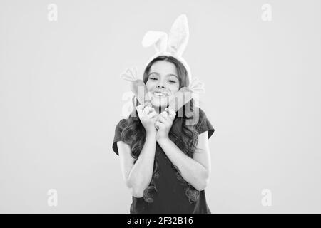 Une alimentation saine est une vie saine. Une enfance saine. Bonne santé pour vos dents. Nibbles carotte comme le lièvre. Enfant dans les oreilles de lapin aime manger la carotte. Enfant lapin Banque D'Images