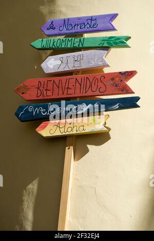 Bienvenue signe dans différentes langues devant un jaune mur Banque D'Images