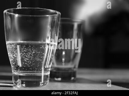 verre d'eau claire et froide posé sur une table en noir et photo de stock blanche Banque D'Images