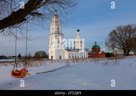 Église de Michael l'Archange à Prozorovo, région de Yaroslavl, Russie. Au premier plan, il y a une balançoire pour enfants accrochée à une branche d'arbre. Banque D'Images
