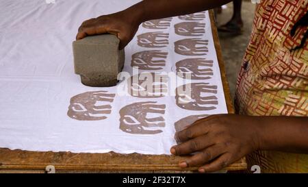 Matériel estampé de cire de batik Accra Ghana. La famille ghanéenne fabrique des impressions africaines traditionnelles à l'aide de cire chaude et de teintures pour tissus. Destination touristique. Banque D'Images
