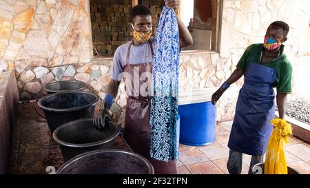 Matériel estampé de cire de batik Accra Ghana. La famille ghanéenne fabrique des impressions africaines traditionnelles à l'aide de cire chaude et de teintures pour tissus. Destination touristique. Banque D'Images