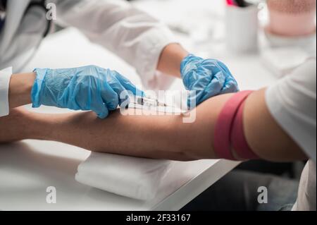 Une infirmière en laboratoire effectue un test sanguin à partir d'une veine, un plan rapproché sans visage Banque D'Images
