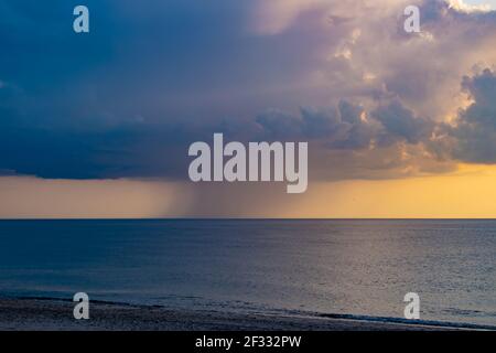 Nuages de pluie au-dessus de la mer du Nord, Danemark, avec des moulins à vent très visibles sous le niveau de l'horizon Banque D'Images