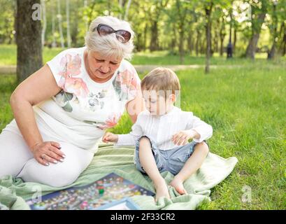 Famille jouant dans la forêt d'été. Des moments heureux avec la grand-mère Banque D'Images