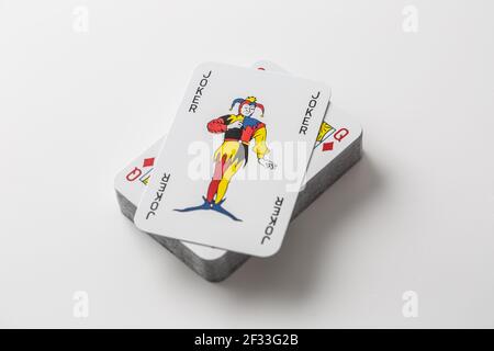 Carte Joker sur le dessus d'une pile de cartes à jouer sur un fond blanc isolé. Banque D'Images