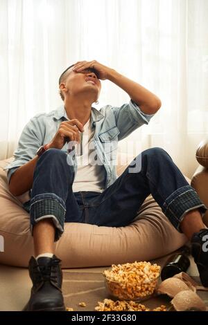 Jeune homme souffrant de maux de tête graves le matin suivant une canettes de boisson rafraîchissante pour faire la fête et boire Banque D'Images