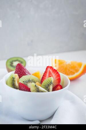 Salade de fruits frais et délicieuse avec fraises et kiwi. Banque D'Images