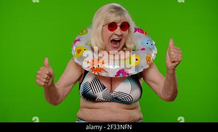 Femme mature touriste levant la main dans le geste victorieux, dansant criant Oui, célébrant le succès Banque D'Images