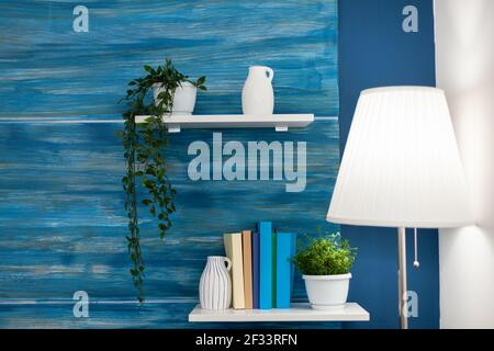 Fleurs vertes sur étagère blanche dans la chambre bleue. Confortable maison salon avec personne dans lui avec belle décoration intérieure. Banque D'Images