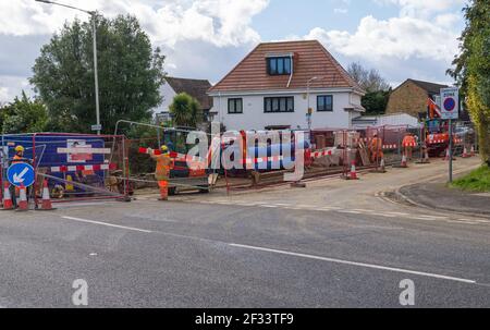 Les excavations de routes et les hommes qui travaillent à la pose de nouvelles conduites d'eau principale. Northwood, Middlesex, Angleterre, Royaume-Uni Banque D'Images