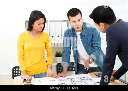 Gens d'affaires occasionnels (architectes ou paysagistes) discuter du plan au bureau Banque D'Images