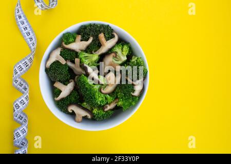 Salade végétarienne avec shiitake aux champignons, brocoli et centimètre blanc sur fond jaune.vue du dessus.espace de copie.ingrédients alimentaires sains. Banque D'Images