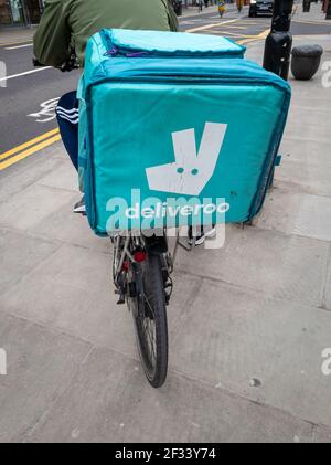 Un cycliste travaillant pour la compagnie de livraison de nourriture en ligne Deliveroo. Banque D'Images