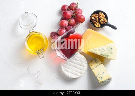 Antipasti assortiment de fromages vin rouge verre camembert dorblu parmesan bio blanc texturé pierre fond avec des rayures naturelles et s Banque D'Images