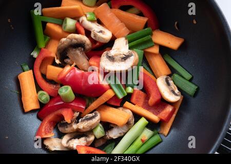 Une variété de légumes colorés coupés pour faire sauter dans un wok. Banque D'Images