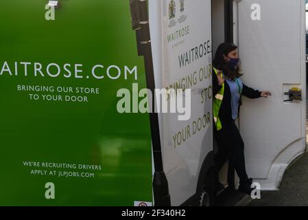 Une livraison d'épicerie à domicile au supermarché Waitrose montrant les enseignes et le logo de l'entreprise sur le véhicule et le conducteur de livraison. Banque D'Images