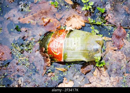 Une vieille bouteille de Coca-Cola rejetée dans l'eau près Banque D'Images