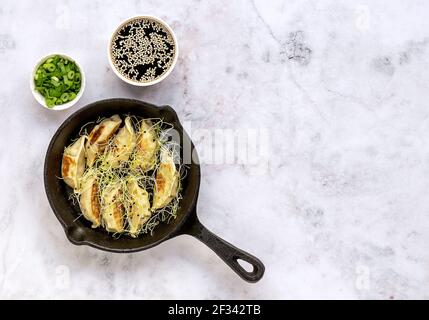 Boulettes végétariennes asiatiques Gyozas frites sur une poêle en fonte Banque D'Images