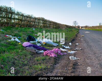 Les déchets domestiques déversés illégalement sur la route, sur une voie de campagne, en hiver. Prise dans le nord-ouest du Royaume-Uni. Banque D'Images