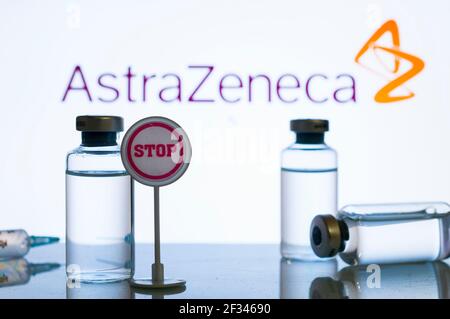 Carrara, Italie - 15 mars 2021 - UN panneau d'arrêt à côté d'un flacon et une silhouette de seringue sur une surface réfléchissante avec le logo AstraZeneca sur le fond Banque D'Images